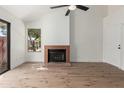Bright living room featuring wood floors, a cozy fireplace, and ample natural light through large windows at 2455 E Broadway Rd # 39, Mesa, AZ 85204