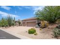 Spacious two-car garage with desert landscaping including a variety of cacti and other plants at 28019 N 115 Pl, Scottsdale, AZ 85262