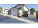 Exterior view of a two-story house featuring a two-car garage and metal gate at 3371 W Grandview Rd, Phoenix, AZ 85053