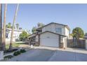 Exterior view of a two-story house featuring a two-car garage and metal gate at 3371 W Grandview Rd, Phoenix, AZ 85053