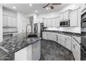 Modern kitchen with white cabinets, a black marble island, and stainless steel appliances at 35616 N 34Th Ln, Phoenix, AZ 85086