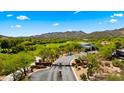 Scenic aerial view of gated community with lush landscaping, golf course, and mountain views at 38940 N 54Th St, Cave Creek, AZ 85331