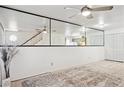 Spacious living room with large mirrored wall, ceiling fan and neutral flooring at 510 N Alma School Rd # 139, Mesa, AZ 85201