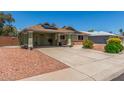 Lovely home showcasing solar panels, covered parking, and attractive decorative rock landscaping at 6014 W Evans Dr, Glendale, AZ 85306