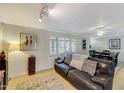 Comfortable living room featuring a leather sofa and bright lighting from the window at 609 E Winter Dr, Phoenix, AZ 85020