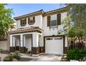 Two-story home featuring a tile roof, a covered porch, and an attached two-car garage at 6343 W Sophie Ln, Laveen, AZ 85339