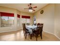 Bright dining room features tile flooring, a ceiling fan, and backyard views from the large windows at 10242 E Pantera Ave, Mesa, AZ 85212
