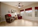 Comfortable living room with tile floors, ceiling fan, and natural light from the large windows at 10242 E Pantera Ave, Mesa, AZ 85212