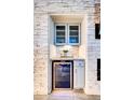 Stylish bar area with a wine refrigerator, granite countertop, and glass door cabinets within a stone feature wall at 1140 E Vermont Dr, Gilbert, AZ 85295