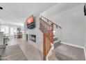 Open-concept living area featuring a fireplace, TV, and staircase with a view of the dining area at 1140 E Vermont Dr, Gilbert, AZ 85295