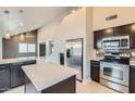 Modern kitchen featuring stainless steel appliances, dark cabinetry, and a bright center island at 1147 E Belmont Ave, Phoenix, AZ 85020