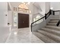 Grand foyer with high ceilings, marble floors, staircase, large window and a beautiful wooden double door at 15215 S 20Th Pl, Phoenix, AZ 85048