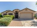 Charming single-story home with a well-manicured front yard, a brick walkway, and a two-car garage at 16605 W Pierce St, Goodyear, AZ 85338