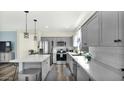 Modern kitchen featuring stainless steel appliances, gray cabinets, and a stylish island with pendant lighting at 18371 W Sunrise Dr, Goodyear, AZ 85338