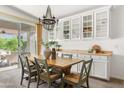 Bright dining area with wood table, stylish chandelier, and sliding door to the patio at 22274 E Cherrywood Ct, Queen Creek, AZ 85142