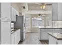 Open kitchen with stainless steel appliances, white cabinets, and wood-look flooring at 2247 W Highland St, Chandler, AZ 85224