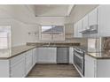 Bright kitchen with stainless steel appliances, granite countertops, and white cabinets at 2247 W Highland St, Chandler, AZ 85224