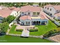 An aerial view of a two-story home featuring a backyard with a dock, covered patio, and lake access at 2454 W Hope Cir, Chandler, AZ 85248