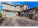Beautiful home featuring a large driveway leading to a two-car garage, set against a blue sky at 2557 N Springfield St, Buckeye, AZ 85396