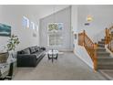 Bright living room featuring soaring ceilings, large windows, and a staircase with wood banister at 285 W Goldfinch Way, Chandler, AZ 85286