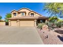 Inviting home featuring a three-car garage, desert landscaping, and a tile roof at 29023 N 46Th Way, Cave Creek, AZ 85331