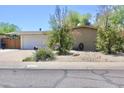 Street view of single-story home featuring a two-car garage and low-maintenance desert landscaping at 3001 W Shaw Butte Dr, Phoenix, AZ 85029