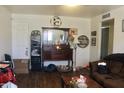 Cozy living room featuring wood laminate flooring, a vintage dresser, and neutral-colored walls at 3001 W Shaw Butte Dr, Phoenix, AZ 85029