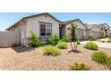Charming single-story home with a gravel yard, and lush landscaping featuring green plants enhancing curb appeal at 31619 N Shady Pasture Ln, San Tan Valley, AZ 85143