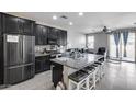 Open-concept kitchen boasts granite countertops, stainless steel appliances, and a large island with bar seating at 42180 W Cheyenne Dr, Maricopa, AZ 85138