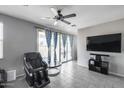 Relaxing living room with a ceiling fan, modern decor, and sliding glass doors to the backyard at 42180 W Cheyenne Dr, Maricopa, AZ 85138