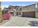 Charming house with a three-car garage, stone accents, and lush green landscaping at 4305 S Antonio --, Mesa, AZ 85212
