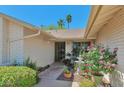 Inviting entryway featuring a well-manicured garden with beautiful flowers and a secure screened front door at 4815 E Everett Dr, Scottsdale, AZ 85254