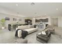 Open-concept living room with modern furnishings and a view of the dining area and kitchen at 5533 N 193Rd Ave, Litchfield Park, AZ 85340