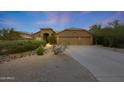 Exterior showcasing desert landscaping, a concrete driveway, and a two-car garage at 6672 E Horned Owl Trl, Scottsdale, AZ 85266