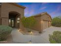 Exterior view featuring manicured landscaping, a two-car garage, and well-lit entryway at 6672 E Horned Owl Trl, Scottsdale, AZ 85266