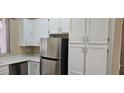This kitchen includes stainless steel appliances and updated white cabinets at 6722 W Shannon St, Chandler, AZ 85226