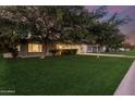 Spacious front yard with lush green grass and mature trees, creating a serene and inviting curb appeal at 728 E State Ave, Phoenix, AZ 85020