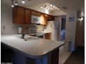 Well-lit kitchen featuring white countertops, tile floors, and wooden cabinets, with an adjacent laundry area at 8651 E Royal Palm Rd # 118, Scottsdale, AZ 85258