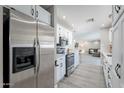 Open kitchen with stainless steel appliances, white cabinets, and a view of the living area at 8716 E Mitchell Dr, Scottsdale, AZ 85251
