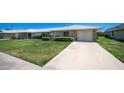 Charming single-story home featuring a manicured lawn, mature shrubs, and a spacious driveway at 9911 W Pleasant Valley Rd, Sun City, AZ 85351