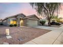 Attractive single-Gathering home with desert landscaping, a two-car garage, and a mature shade tree at 13159 W Caribbean Ln, Surprise, AZ 85379