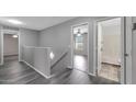 Upstairs hallway with wood floors leads to a bathroom and bedroom at 13261 W Gelding W Cir, Surprise, AZ 85379