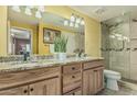 Well-lit bathroom with a double vanity, granite countertop, and a glass-enclosed shower at 145 N 74Th St # 240, Mesa, AZ 85207