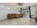Inviting living room with plush seating, a ceiling fan, and access to the backyard at 15140 W Glenrosa Ave, Goodyear, AZ 85395