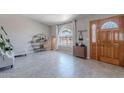 Bright living room featuring tile floors, a front door, and a large window with natural light at 1811 E Tierra Buena Ln, Phoenix, AZ 85022
