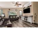 Inviting living room featuring wood-look floors, a ceiling fan, and comfortable leather seating at 2038 N Los Alamos St, Mesa, AZ 85213