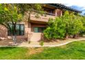 Beautiful lawn and gravel around condo building with a tree and a balcony above at 20660 N 40Th St # 1118, Phoenix, AZ 85050