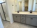 Elegant bathroom with double vanity, sleek black fixtures, and glass-enclosed shower at 22382 W Monona Ln, Surprise, AZ 85387