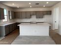 Modern kitchen with ample cabinet space, sleek countertops, a large center island, and stainless steel appliances at 22382 W Monona Ln, Surprise, AZ 85387