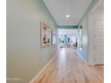 Inviting hallway with wood-look tile flooring and modern decor, leading to the open-concept living spaces at 25338 N 150Th Ln, Surprise, AZ 85387